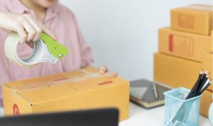 Homem segurando a caixa de uma remessa internacional 