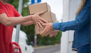 Entregador fazendo a coleta de encomenda na casa do cliente 