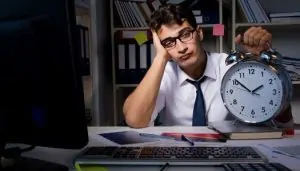 Homem triste segurando um relógio preocupado com o horário